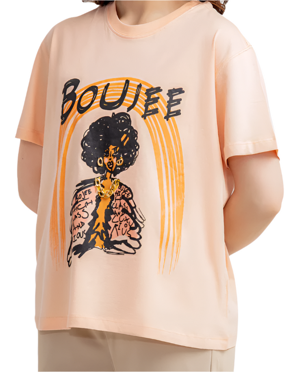 Person wearing a peach t-shirt with a graphic design and text on a white background